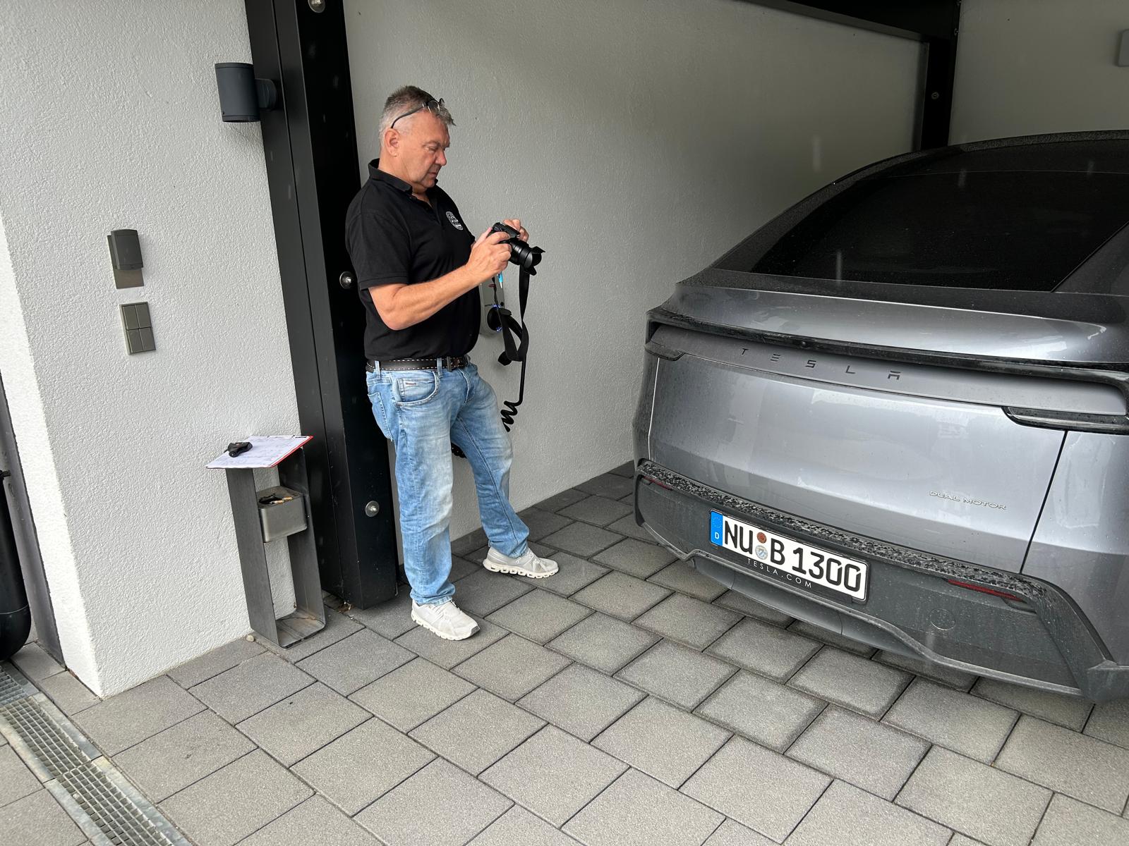 Kfz-Sachverständiger Wolfgang Merkle bei der Fotodokumentation eines Unfallschadens